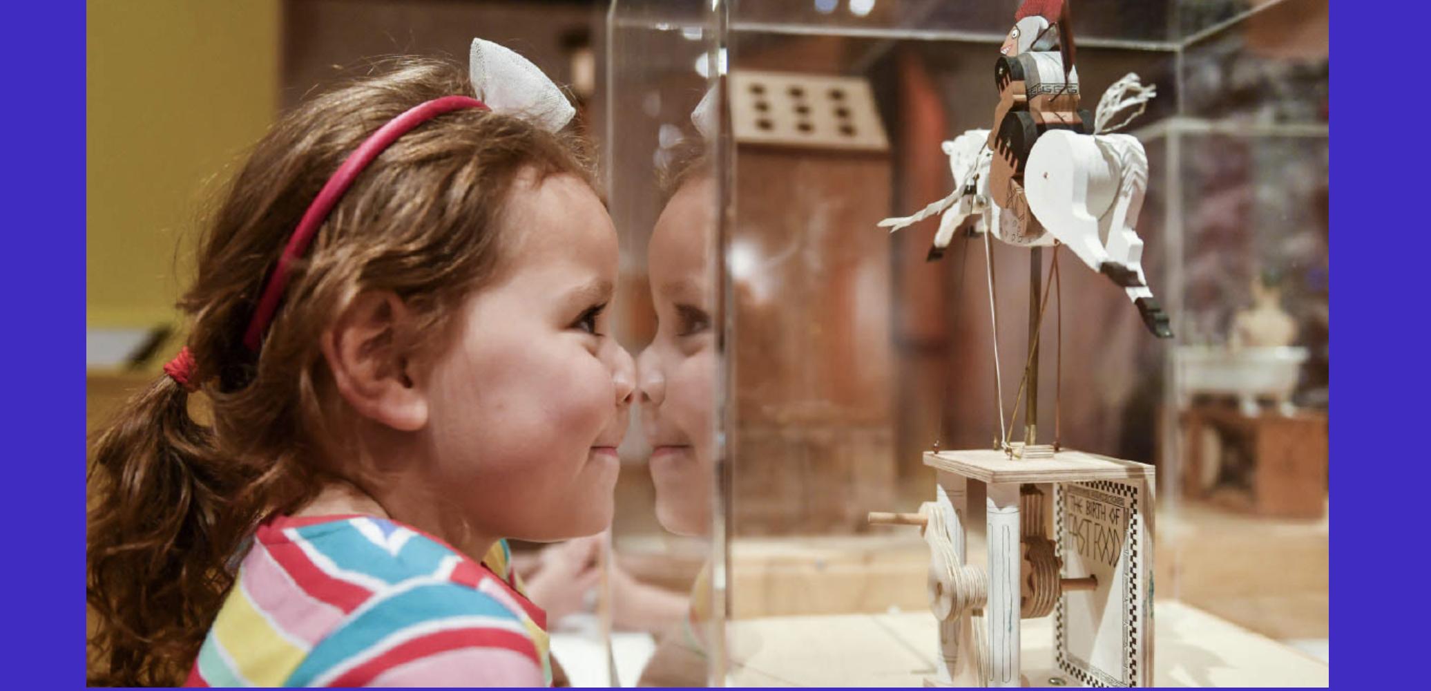 Child with nose pressed against a glass display
